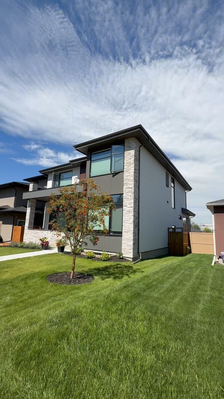 Calgary custom home with smooth grey stucco and contrasting light stone columns