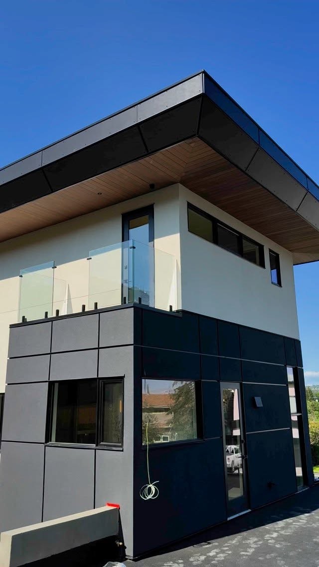 Contemporary two-storey home with smooth stucco, charcoal panels and wood soffit